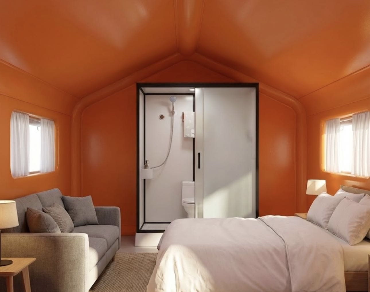 Interior of an inflatable membrane pod as a suite with double bed, sofa and private bathroom