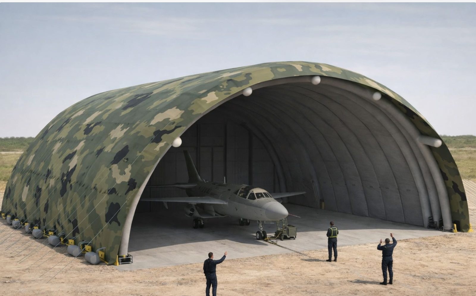 Camouflage-finish wide-span inflatable membrane hangar with a fixed-wing aircraft inside